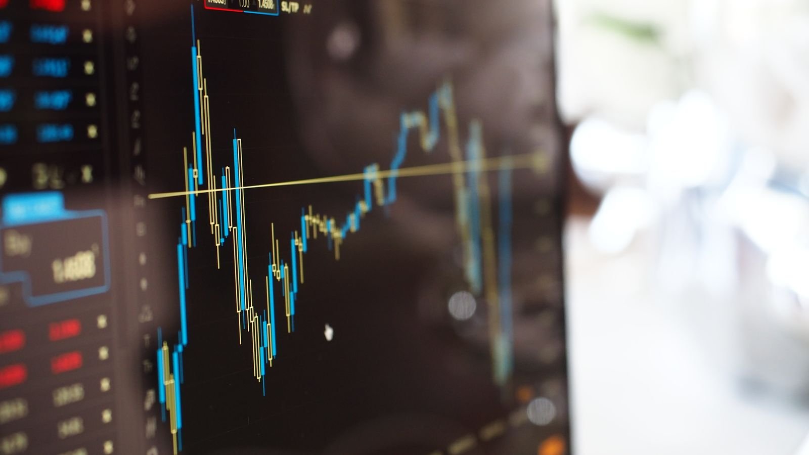 Close-up of a digital screen showing financial trading graphs, representing GDP components and economic data trends