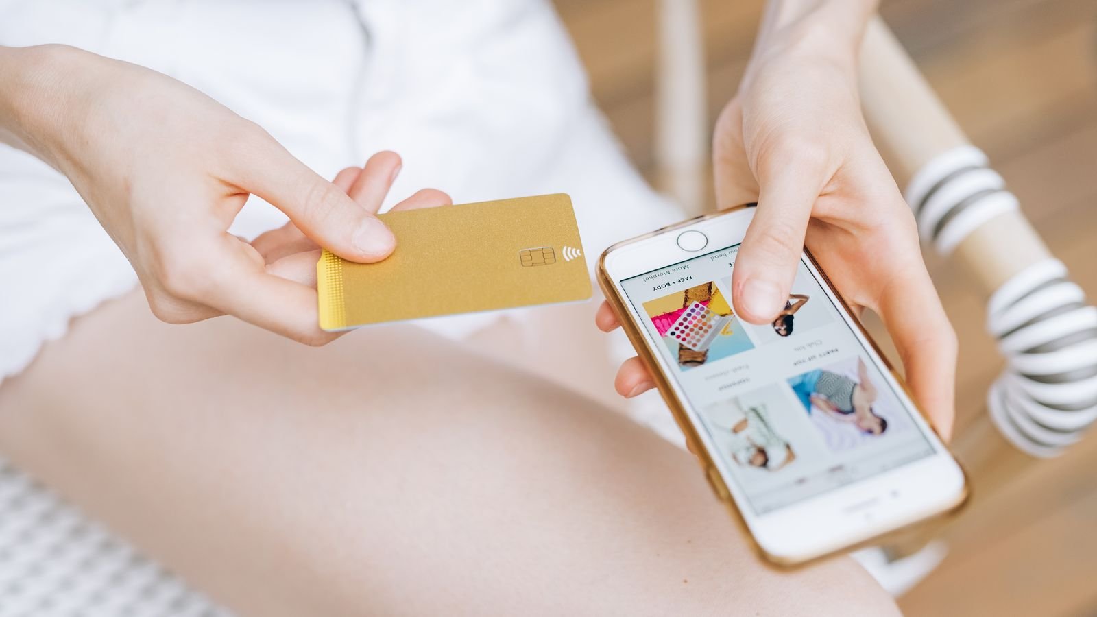 A woman holding a smartphone and credit card while shopping online, representing e-commerce and digital retail sales growth