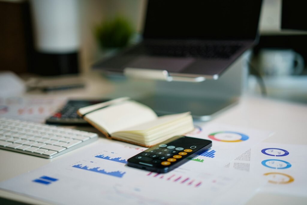 Office desk with smartphone and financial charts used to review company buyback funding