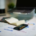 Office desk with smartphone and financial charts used to review company buyback funding