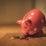 Pink piggy bank on a wooden table representing savings and inflation protection