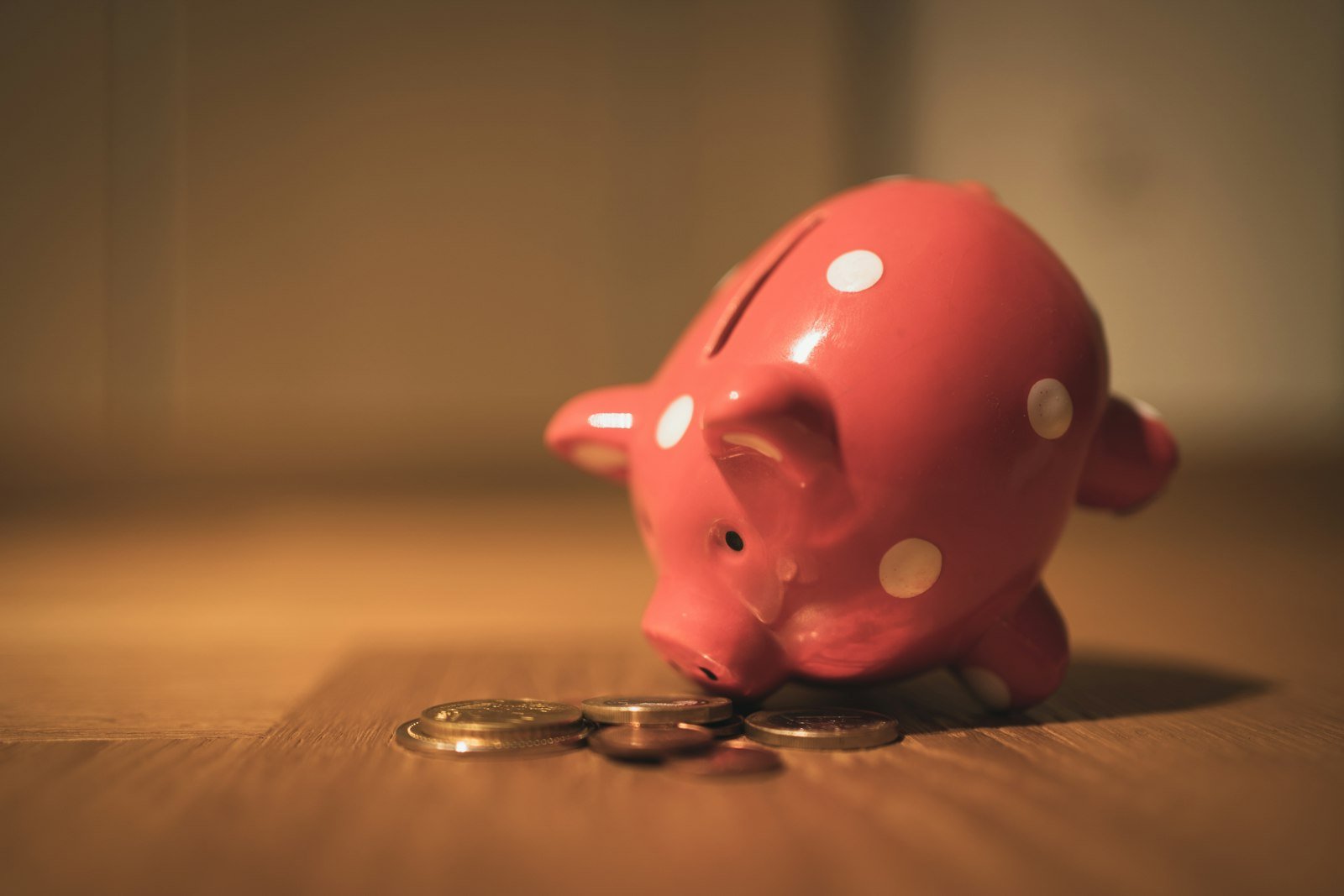 Pink piggy bank on a wooden table representing savings and inflation protection