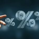 Hand reaching toward floating percentage symbols representing interest rates